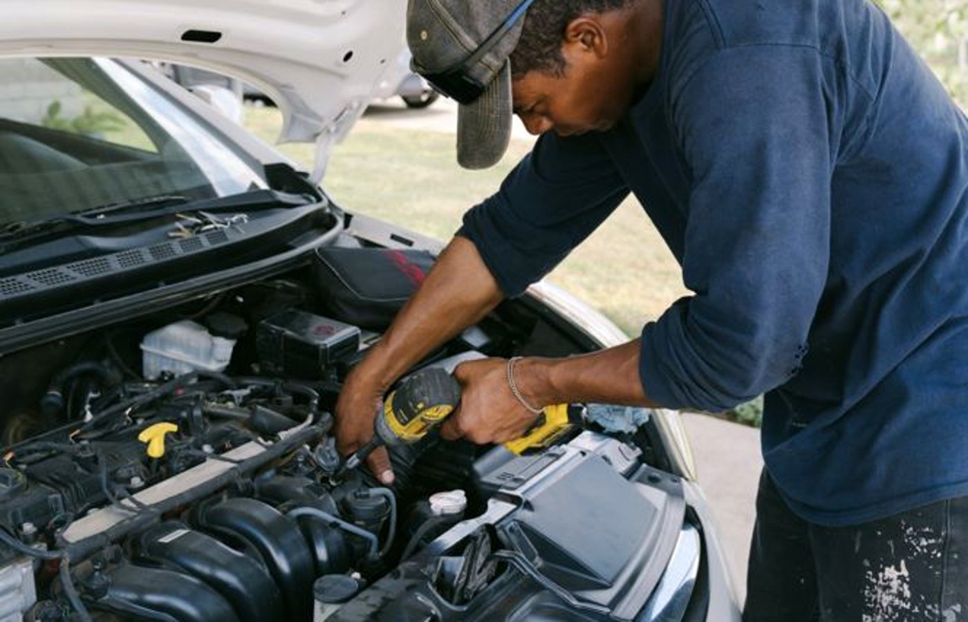Dusty pickup truck engine bay being inspected in West Texas wind